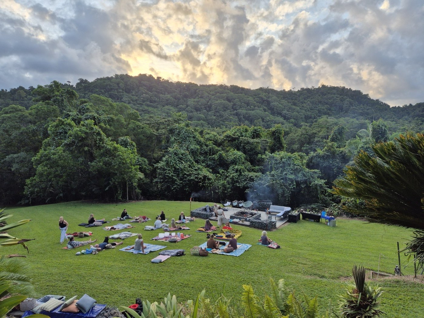 The rainforest amphitheatre at golden hour, mats and fire pit ready