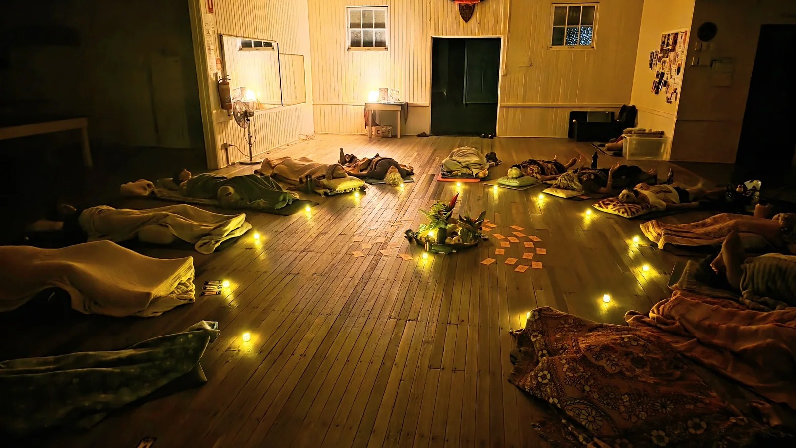 Buffs Hall by candlelight, the room laid out with mats and blankets for a Tuesday session.